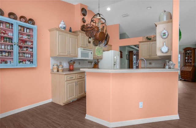 kitchen with kitchen peninsula, decorative backsplash, dark hardwood / wood-style flooring, white appliances, and sink