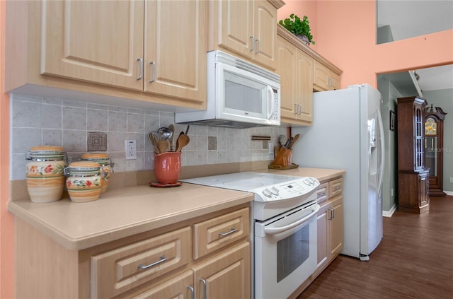 kitchen featuring dark hardwood / wood-style flooring, white appliances, light brown cabinetry, and tasteful backsplash