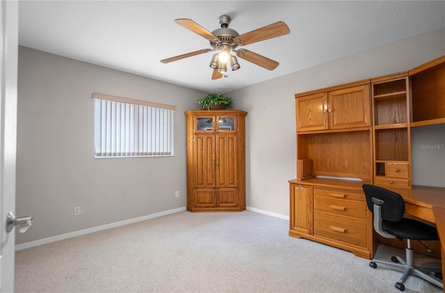 office space with ceiling fan and light carpet