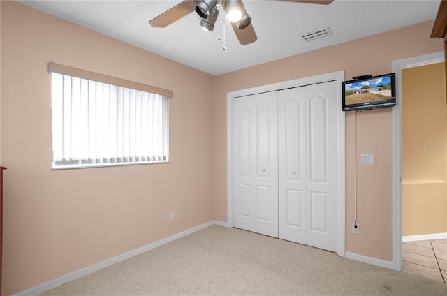 unfurnished bedroom featuring ceiling fan, light carpet, and a closet