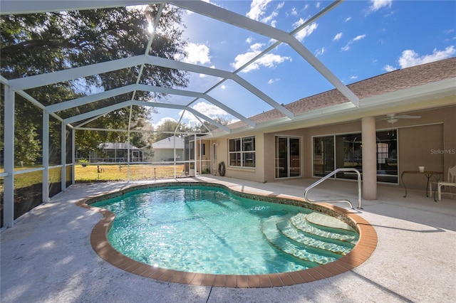 view of swimming pool with ceiling fan, a patio area, and a lanai