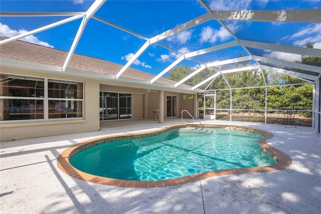 view of pool with a patio area and glass enclosure