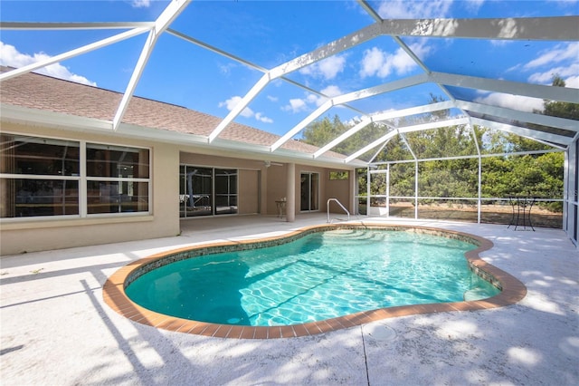 view of pool with glass enclosure and a patio area