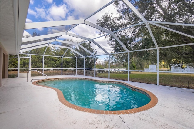 view of pool with glass enclosure, a patio area, and a yard