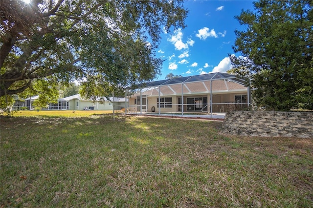 rear view of house featuring a yard and a lanai