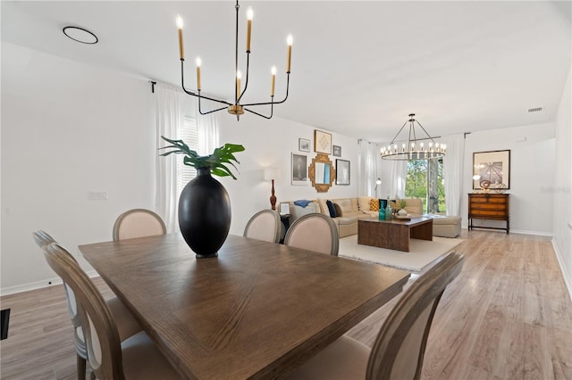 dining space with a chandelier and light hardwood / wood-style flooring