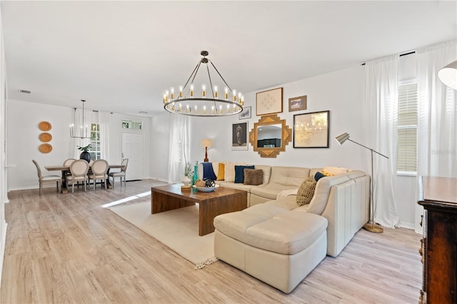 living room featuring a notable chandelier and light wood-type flooring