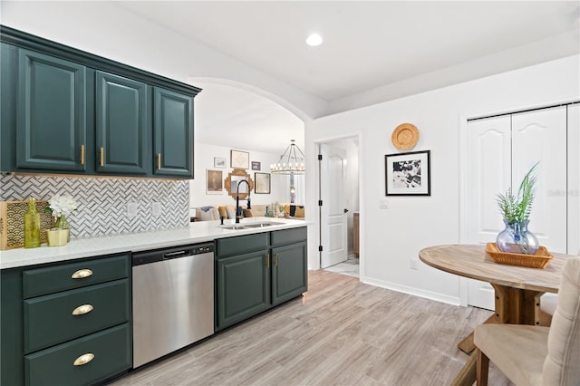 kitchen with dishwasher, sink, tasteful backsplash, light hardwood / wood-style floors, and decorative light fixtures