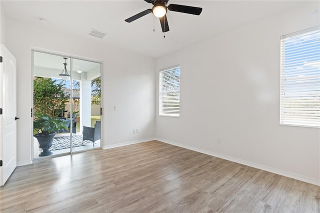 empty room featuring light wood-type flooring, plenty of natural light, and ceiling fan