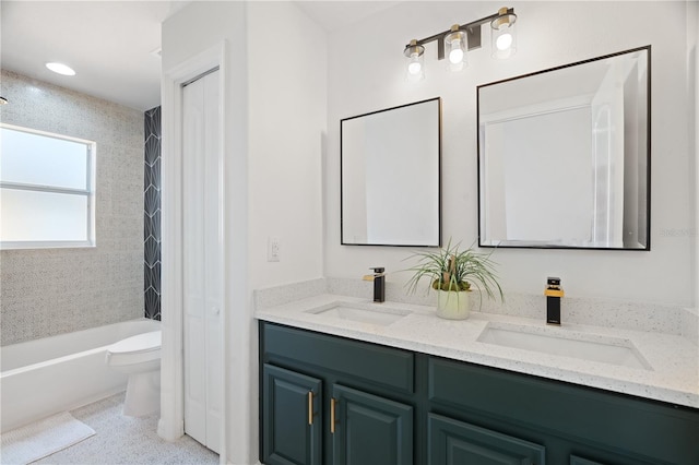 full bathroom with vanity, tiled shower / bath combo, and toilet