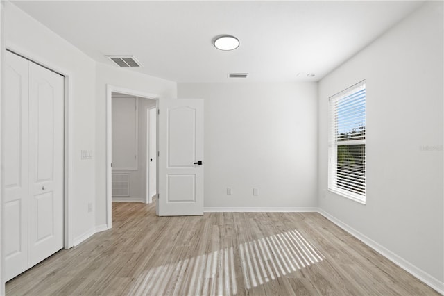 unfurnished bedroom featuring light hardwood / wood-style floors and a closet