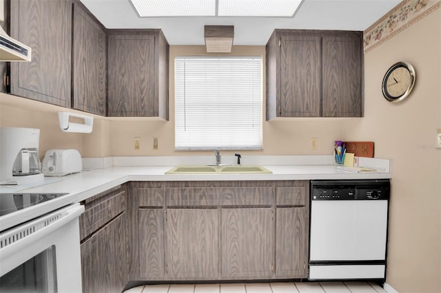 kitchen featuring white dishwasher, light tile patterned floors, sink, and extractor fan