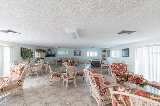 dining room with light tile patterned flooring, a textured ceiling, and pool table