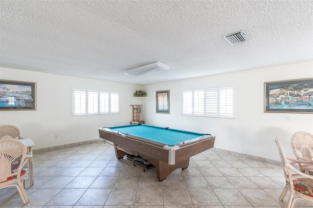 rec room with a wealth of natural light, light tile patterned floors, a textured ceiling, and pool table