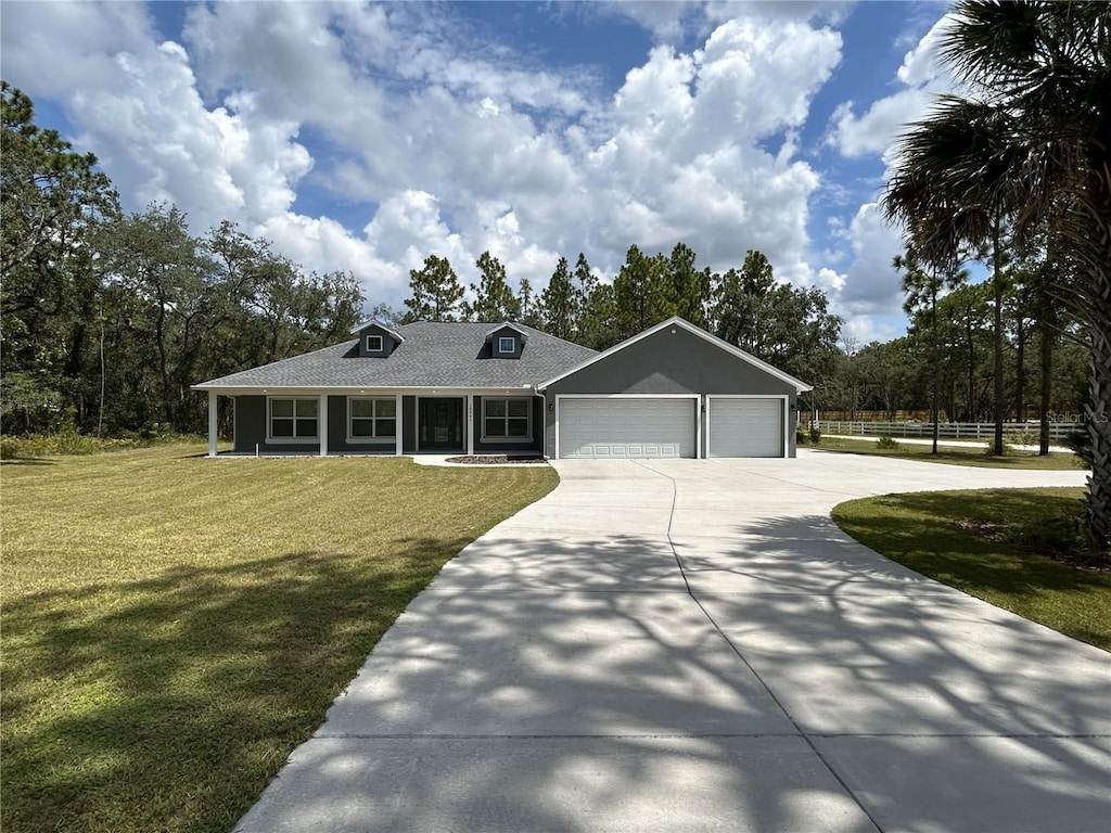 view of front of property featuring covered porch, a front yard, and a garage