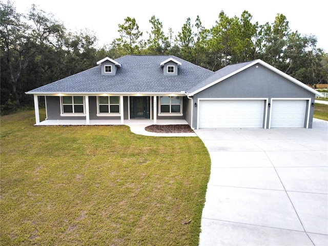 view of front of property featuring covered porch, a front yard, and a garage