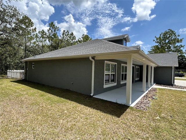 view of side of property featuring a patio and a lawn