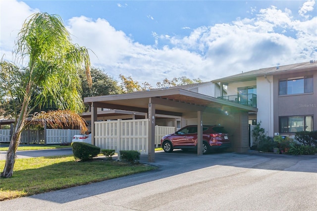 view of vehicle parking featuring a yard and a carport