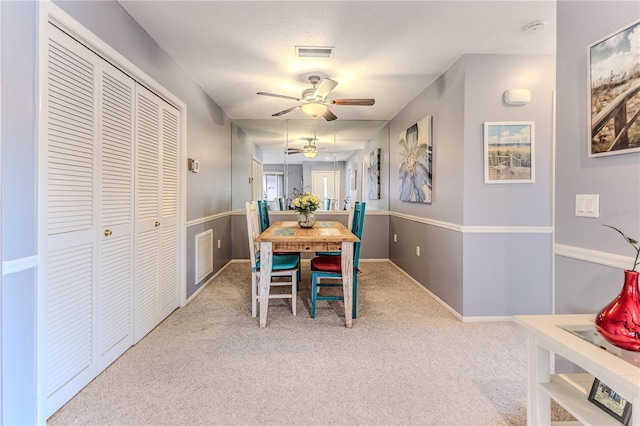 carpeted dining space featuring ceiling fan