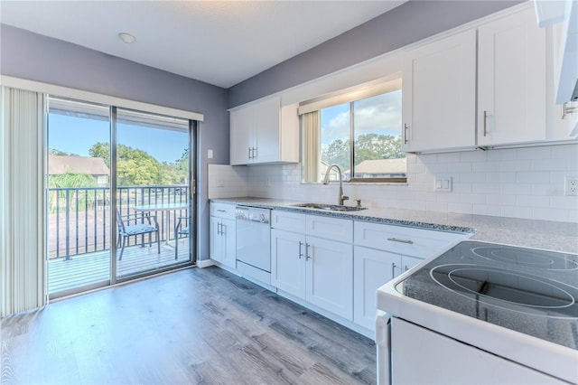 12814 Wedgewood Way Unit C, Hudson, FL 34667 - kitchen with white appliances, white cabinets, light wood-type flooring, decorative backsplash, and light stone countertops