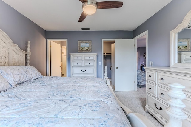 bedroom featuring a closet, light colored carpet, a spacious closet, and ceiling fan