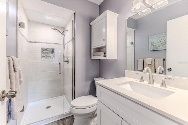 bathroom featuring hardwood / wood-style flooring, vanity, an enclosed shower, and toilet