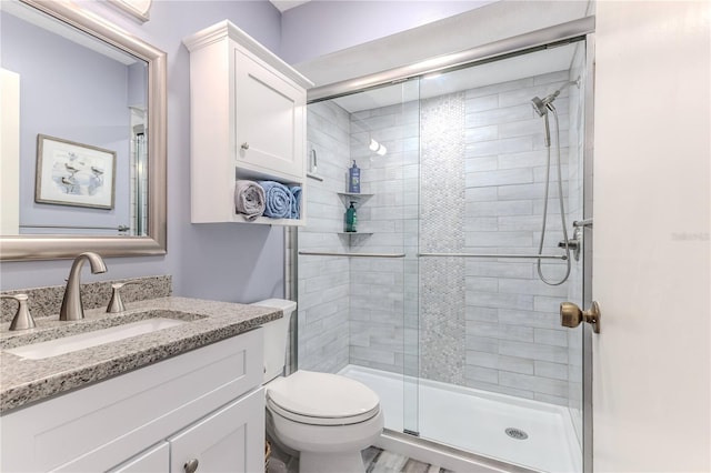 bathroom with vanity, toilet, and an enclosed shower