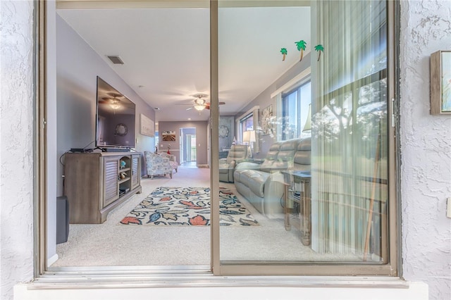 living room featuring carpet and ceiling fan