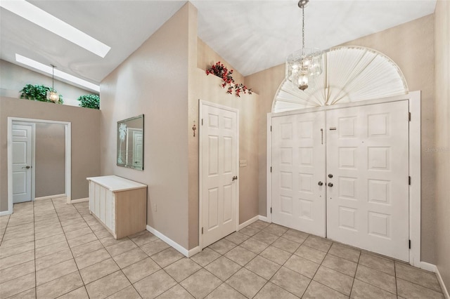 tiled foyer featuring high vaulted ceiling and a notable chandelier