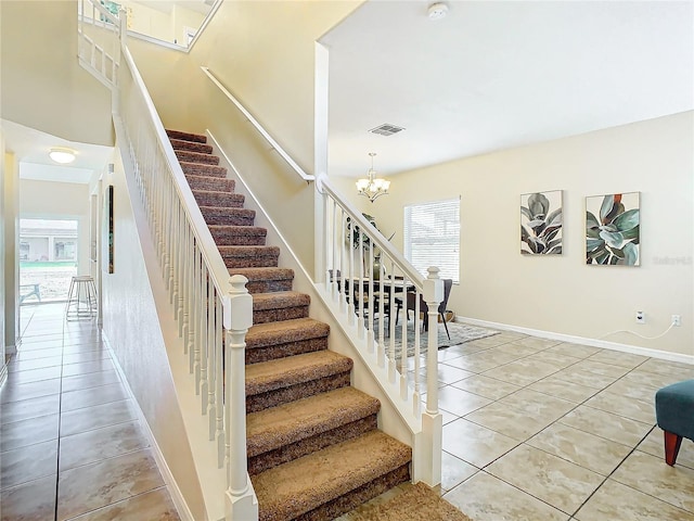 stairway featuring tile patterned floors, plenty of natural light, and an inviting chandelier