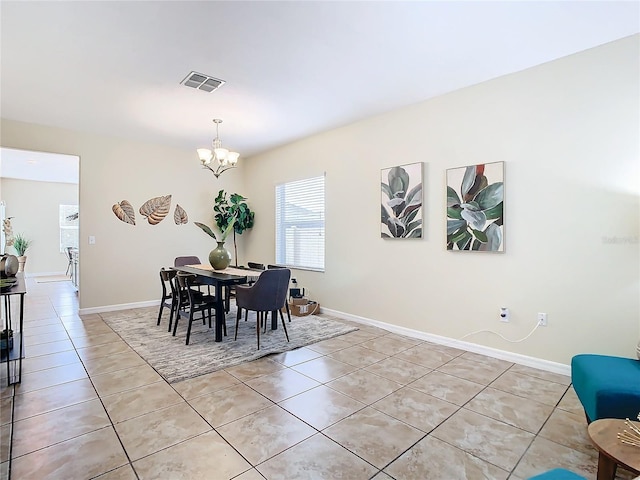 dining area with light tile patterned floors and an inviting chandelier