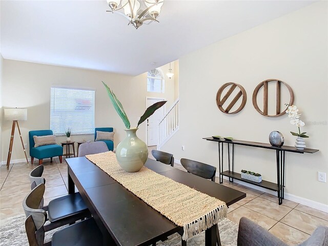 dining area with a chandelier and light tile patterned floors