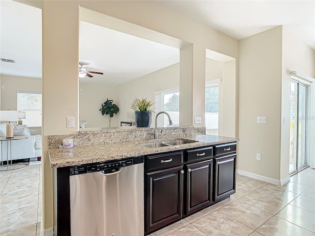 kitchen with ceiling fan, sink, light stone counters, stainless steel dishwasher, and light tile patterned floors