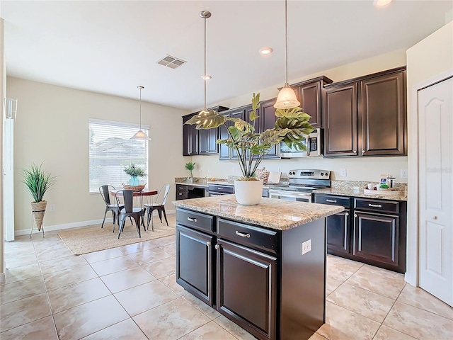 kitchen featuring appliances with stainless steel finishes, dark brown cabinetry, a center island, hanging light fixtures, and light tile patterned flooring