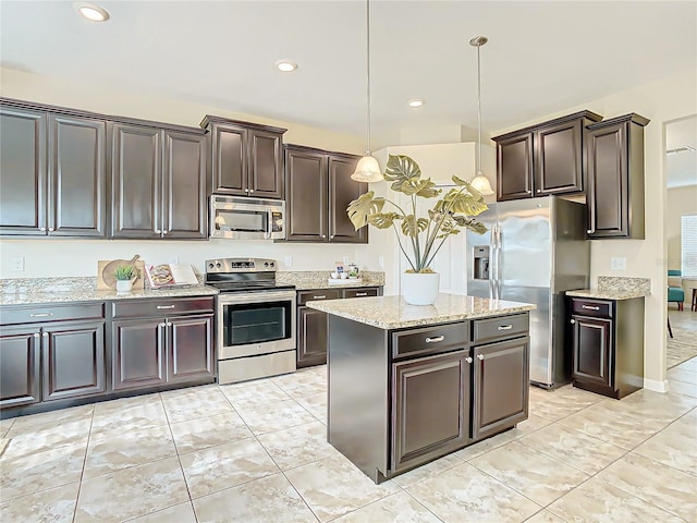 kitchen with decorative light fixtures, a center island, stainless steel appliances, and dark brown cabinets