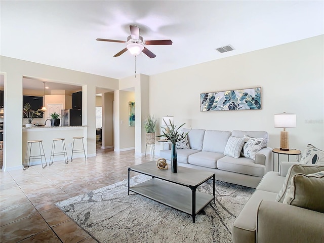 living room featuring tile patterned floors and ceiling fan