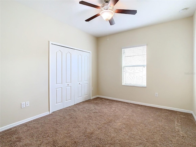 unfurnished bedroom featuring ceiling fan, a closet, and carpet