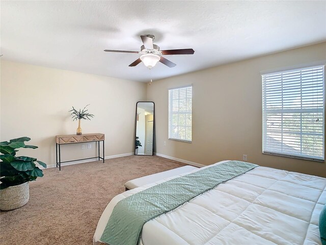 bedroom featuring multiple windows, carpet floors, and ceiling fan