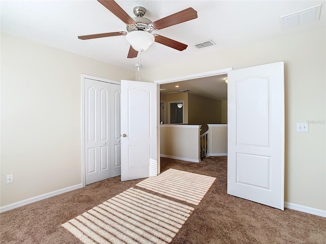 unfurnished bedroom with dark carpet, a closet, and ceiling fan