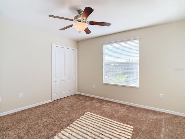 unfurnished bedroom featuring ceiling fan, carpet floors, and a closet