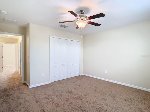 unfurnished bedroom featuring ceiling fan, a closet, and carpet