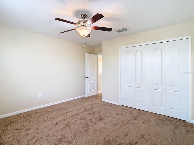 unfurnished bedroom with carpet flooring, ceiling fan, and a closet