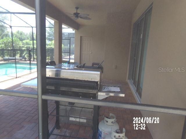 5537 Misty Oak Cir, Davenport, FL 33837 - view of patio / terrace featuring an outdoor pool, a ceiling fan, a lanai, and exterior kitchen