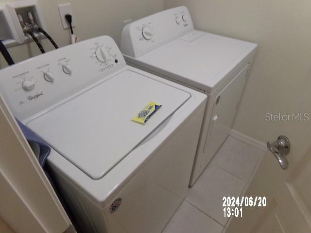 laundry area with tile patterned flooring and washing machine and dryer