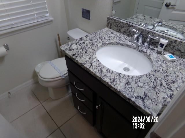 bathroom featuring tile patterned flooring, vanity, and toilet