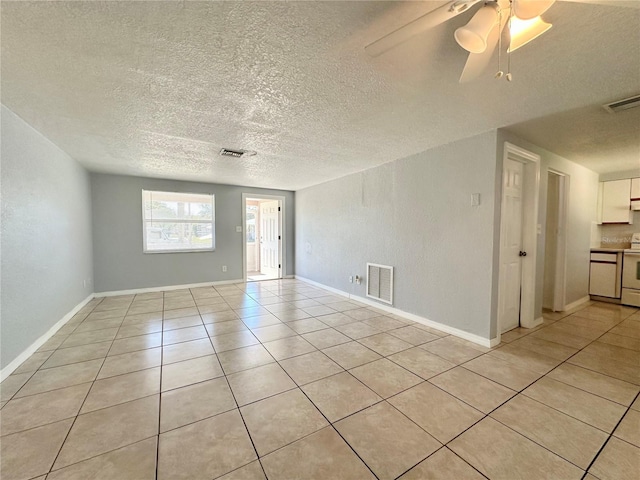 spare room with light tile patterned floors, a textured ceiling, and ceiling fan