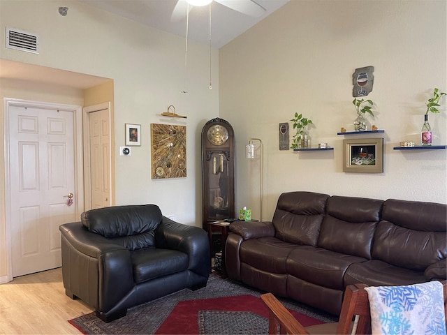 living room featuring light hardwood / wood-style flooring, ceiling fan, and lofted ceiling