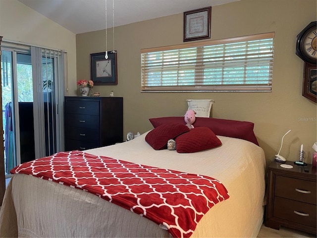 bedroom with access to exterior and lofted ceiling