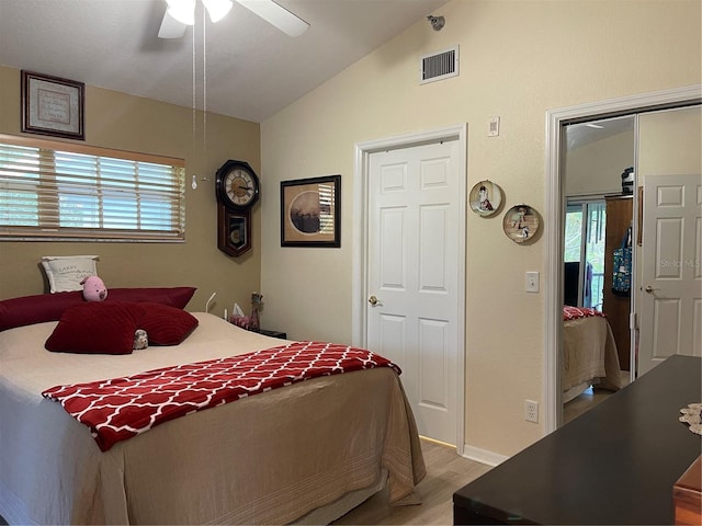 bedroom with ceiling fan, vaulted ceiling, and light hardwood / wood-style flooring