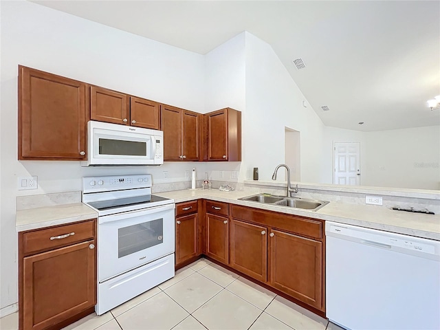 kitchen with sink, kitchen peninsula, lofted ceiling, white appliances, and light tile patterned floors